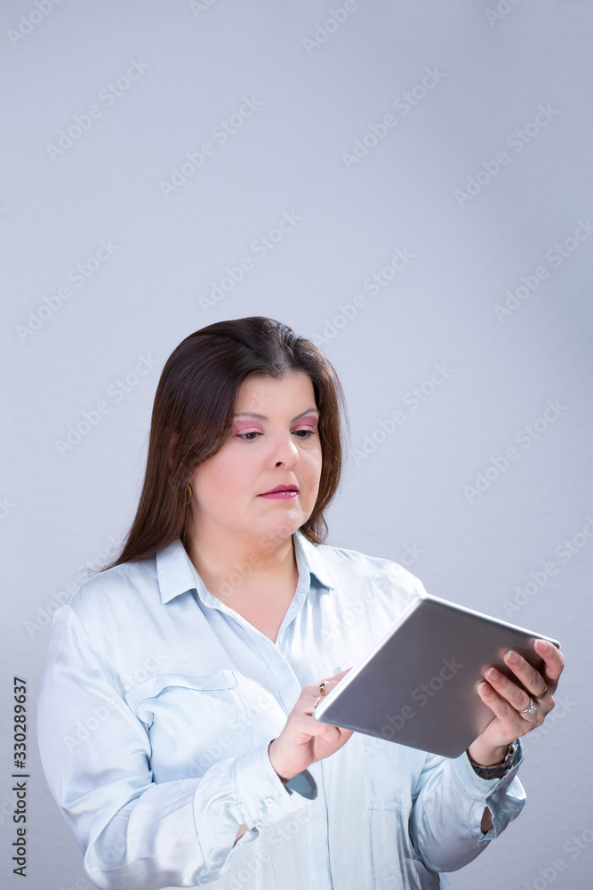 Business Woman Poses for a Studio Portrait. She is using a tablet as a work tool. Business Woman Poses for a Studio Portrait. She is using a tablet as a work tool.