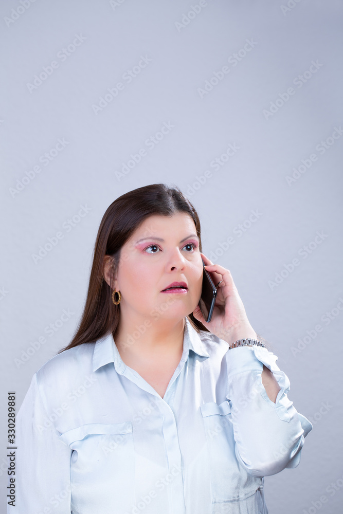 Business Woman Poses for a Studio Portrait. She is speaking on her smartphone. Business Woman Poses for a Studio Portrait. She is speaking on her smartphone.