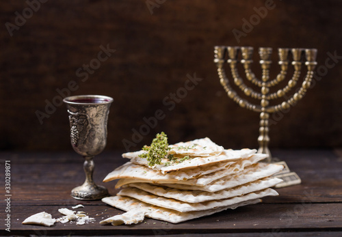 Red kosher wine with a white  matzah or matza on a vintage wood background presented as a Passover seder meal with copy space. photo