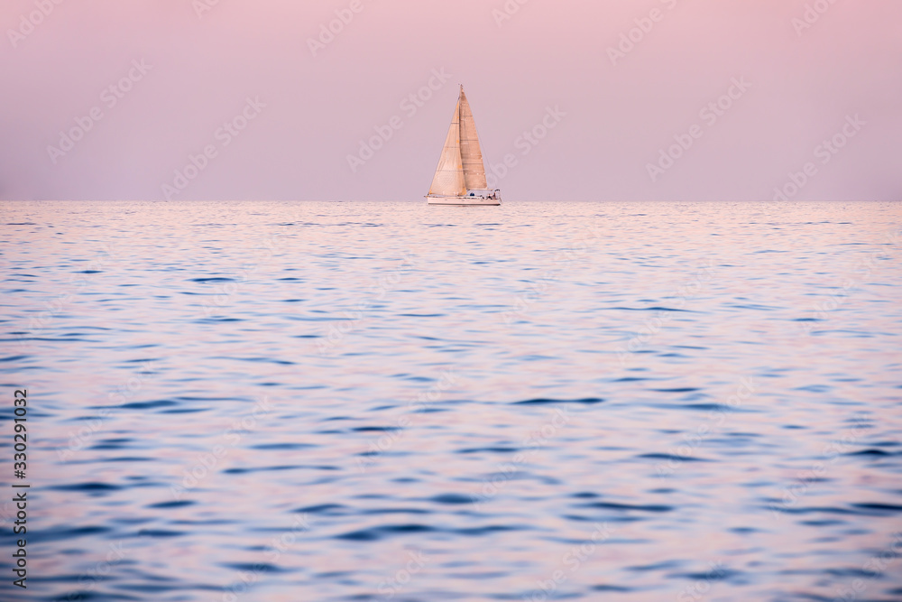 A romantic seascape with a sail boat after sunset, taken in Malta.