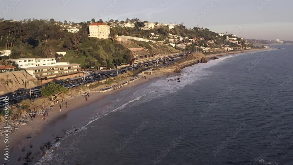 Pullback reveal aerial view of Late afternoon traffic on California State Route one with Pacific Coastline and surrounding nature. Pullback reveal aerial view of Late afternoon traffic on California State Route one with Pacific Coastline and surrounding nature.