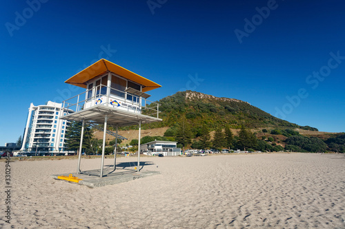 MOUNT MAUNGANUI, NEW ZEALAND - MARCH 6, 2020: The Surf Lifesaving tower stands ready on the Mount Main Beach on a beautiful sunny blue sky Autumn day