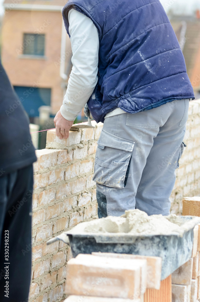 masons working on a construction site close up masons working on a construction site close up