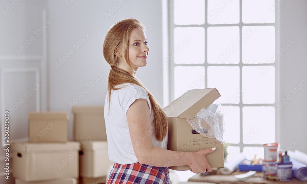 A beautiful single young woman unpacking boxes and moving into a new home A beautiful single young woman unpacking boxes and moving into a new home