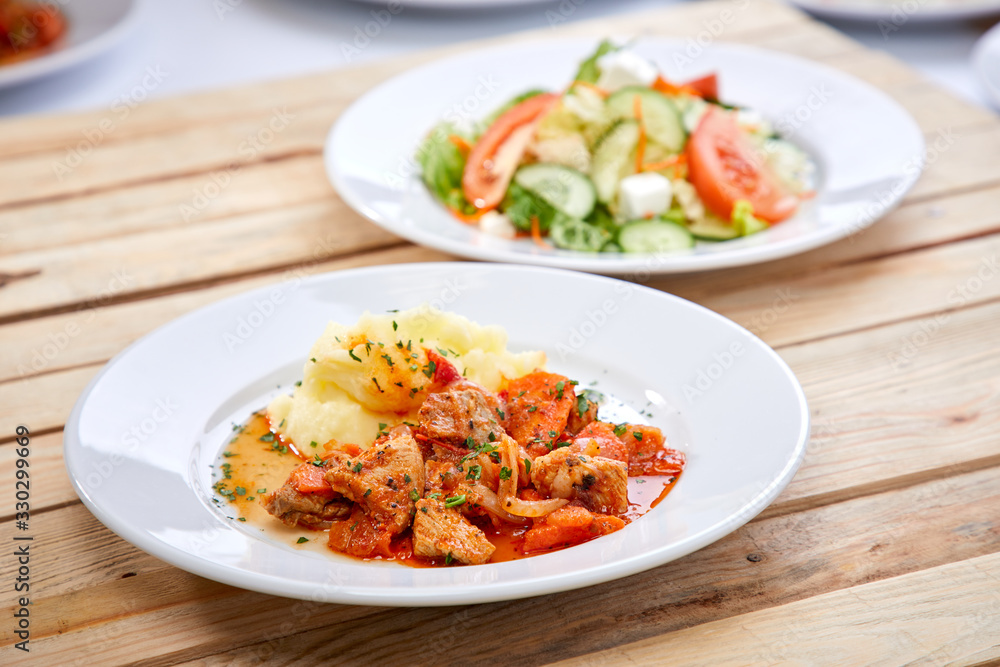 chicken with mashed potatoes and salad on the wooden background