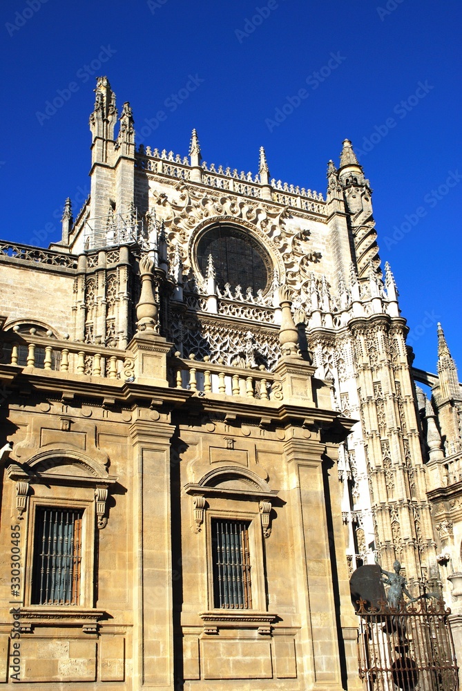 Cathedral of Saint Mary of the See featuring the main doorway (Puerta de San Cristobal) and La Giralda statuette, Seville, Spain.