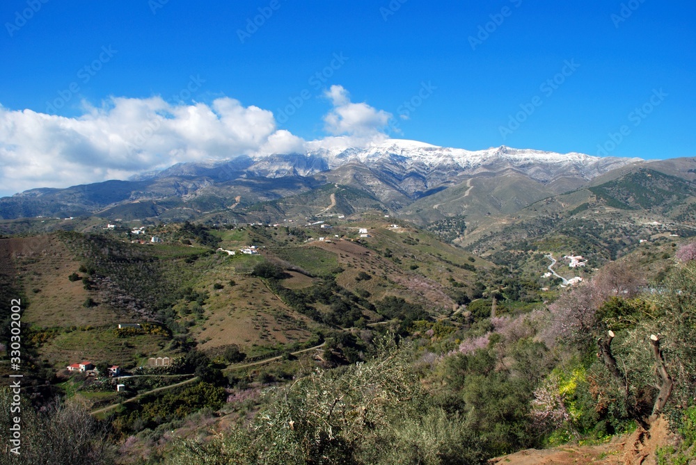 View across the countryside towards snow capped mountains, Salares, Spain.