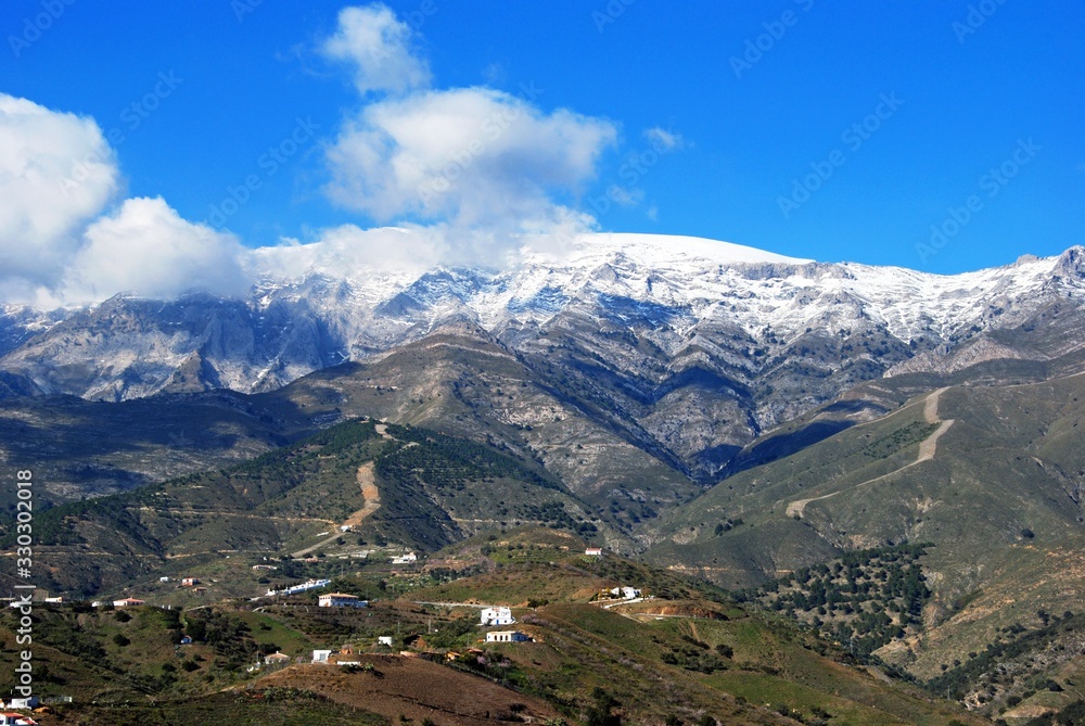 View across the countryside towards snow capped mountains, Salares, Spain.