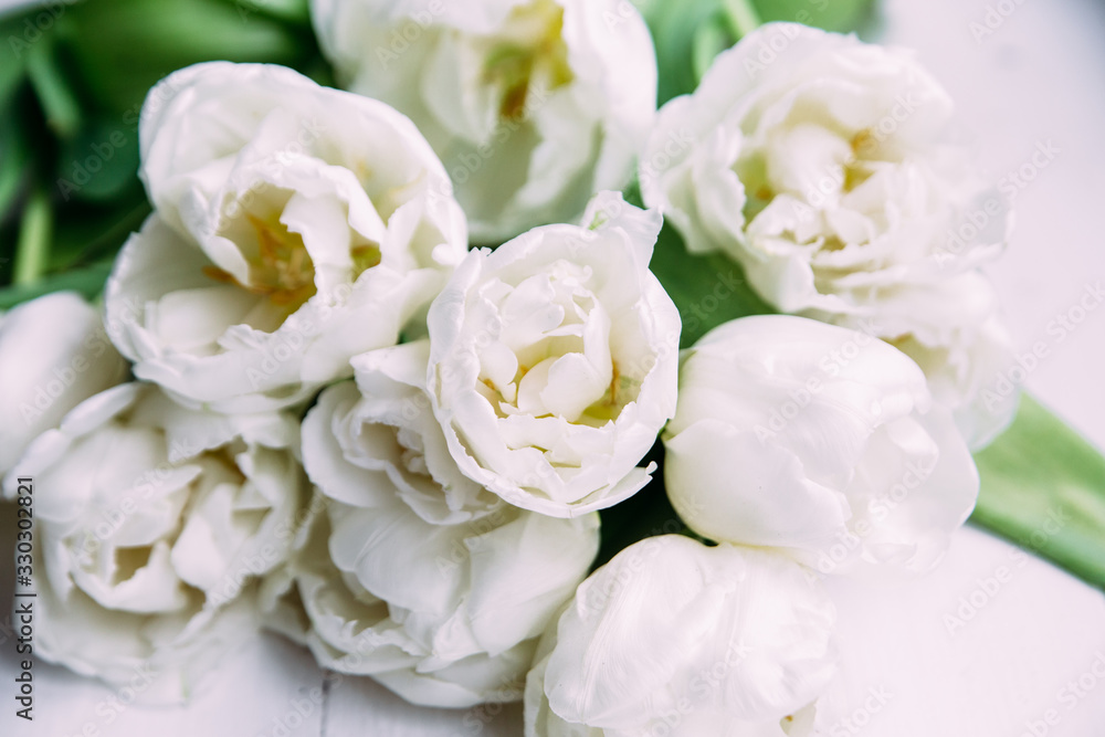Bouquet of white tulips on a wooden background with space for text. 