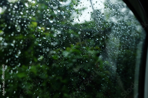 Dew and Raindrops on a window glass in natural rainforest