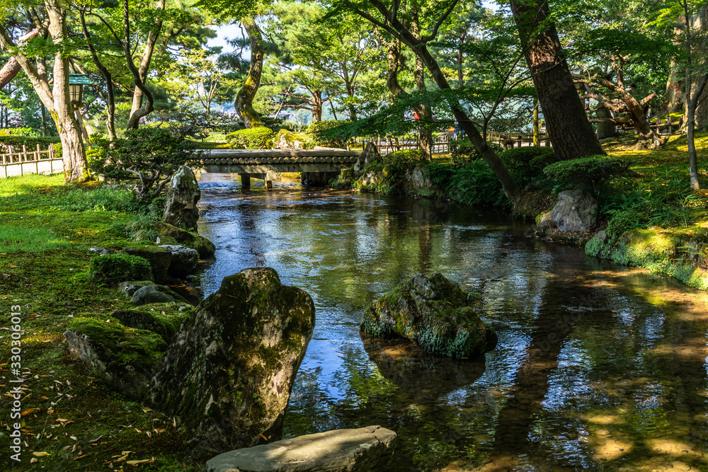 Fototapeta premium Lush vegetation during summer at Kenrokuen in Kanazawa, the most celebrated landscape garden of Japan