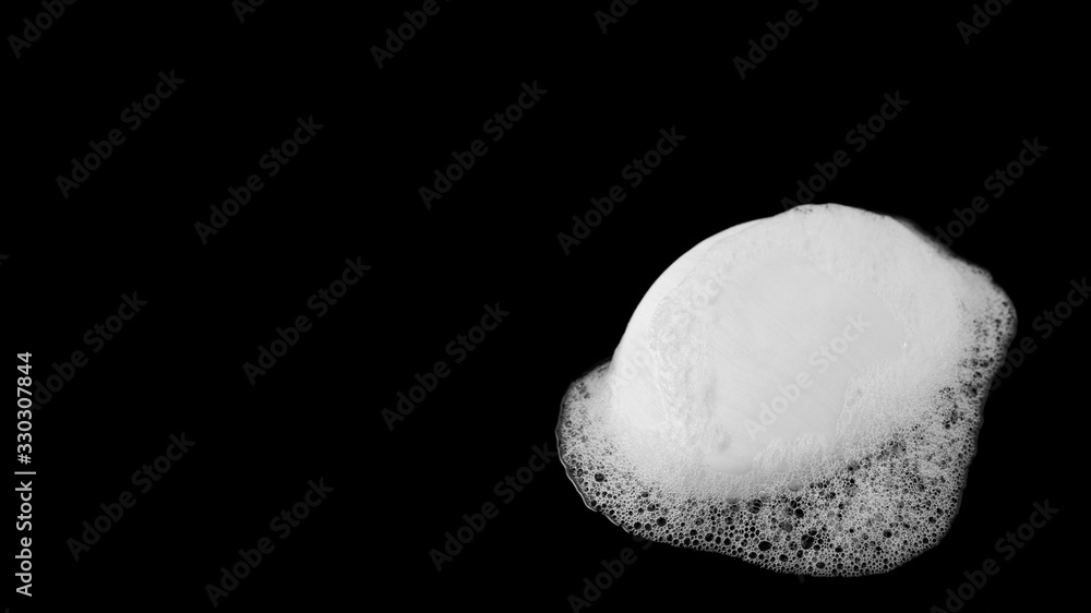 Bar of soap and suds on black with copy space Bar of soap and suds on black with copy space