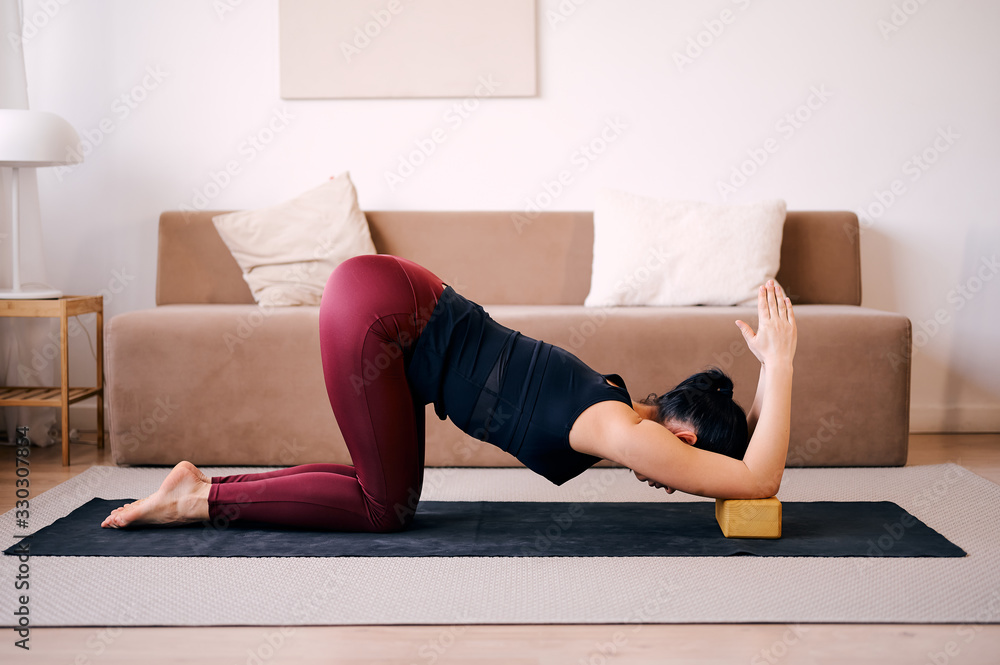 Woman practicing yoga stretching using wooden blocks Woman practicing yoga stretching using wooden blocks