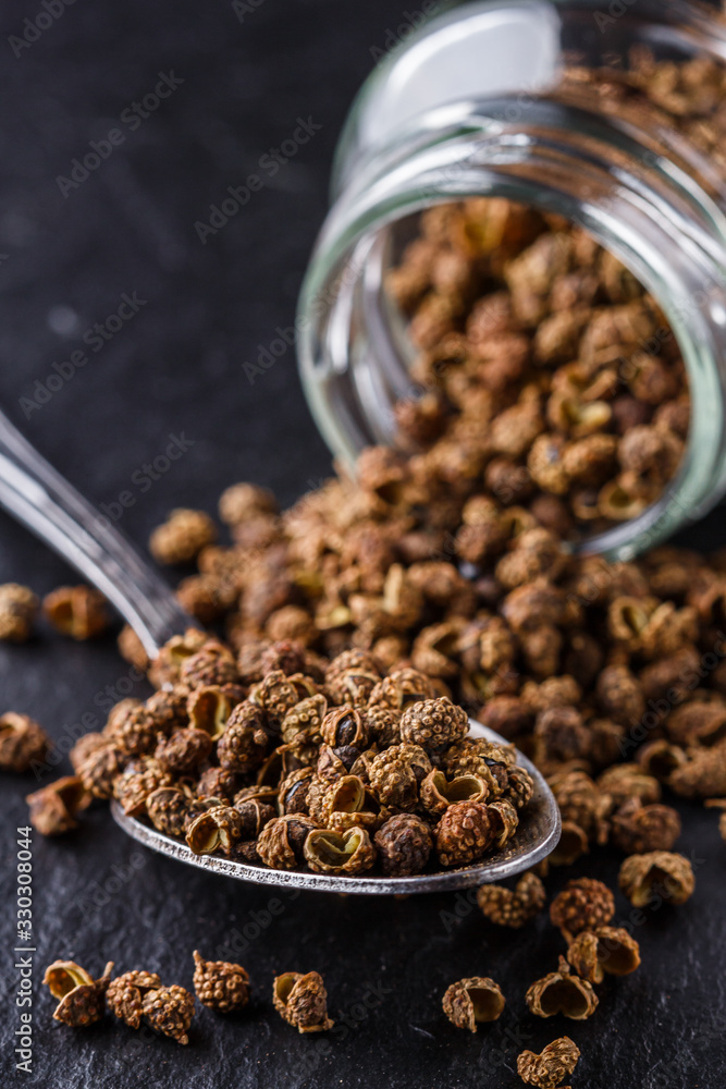 Sichuan pepper on a dark stone background Sichuan pepper on a dark stone background