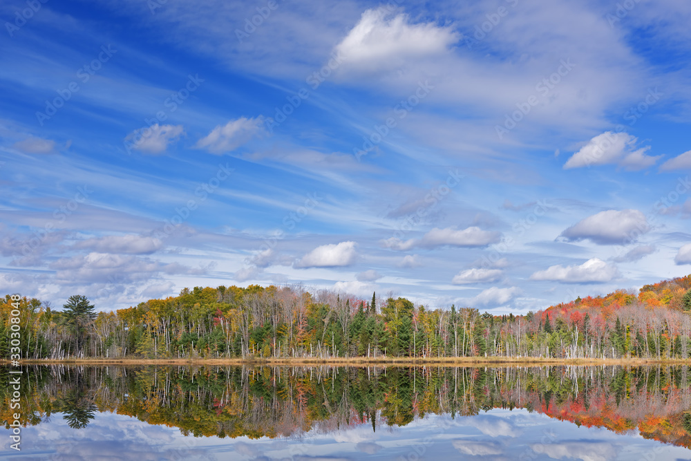Autumn landscape of Council Lake with reflections of trees and clouds in calm water, Hiawatha National Forest, Michigan's Upper Peninsula, USA Autumn landscape of Council Lake with reflections of trees and clouds in calm water, Hiawatha National Forest, Michigan's Upper Peninsula, USA