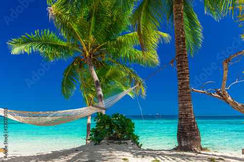 Fototapeta Naklejka Na Ścianę i Meble -  Palm trees on a white sandy beach at Plantation Island, Fiji, South Pacific
