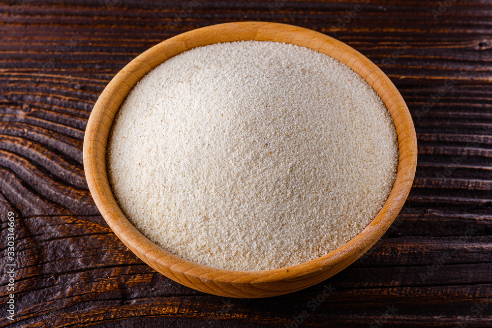 natural organic semolina on dark wooden rustic background natural organic semolina on dark wooden rustic background