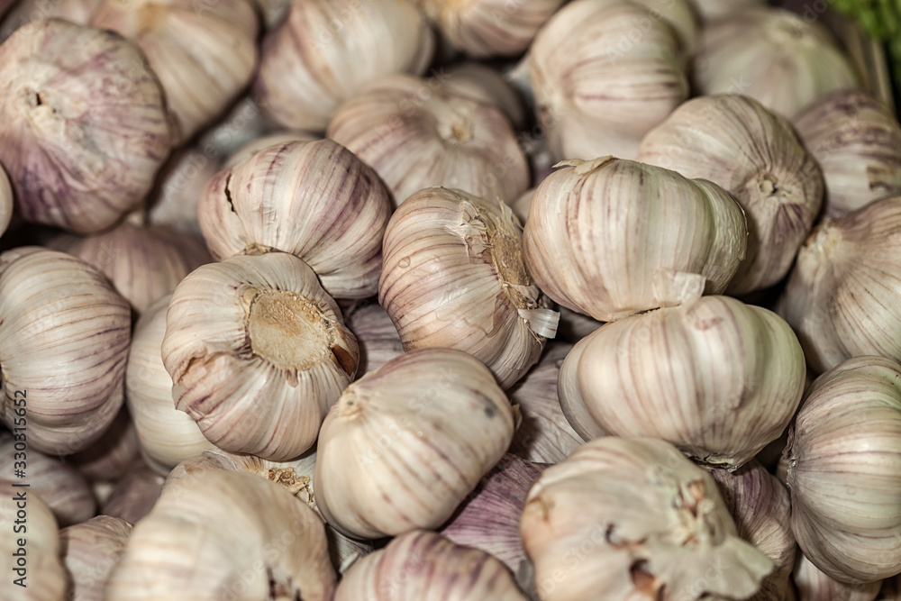 White garlic pile texture. Fresh garlic on market table closeup photo White garlic pile texture. Fresh garlic on market table closeup photo