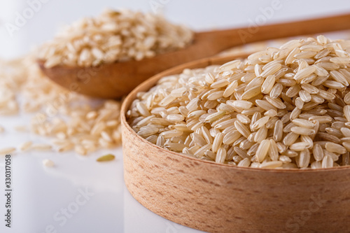 raw brown rice on white acrylic background