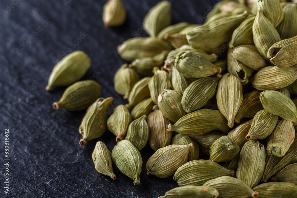 fragrant green cardamom on a dark stone background fragrant green cardamom on a dark stone background