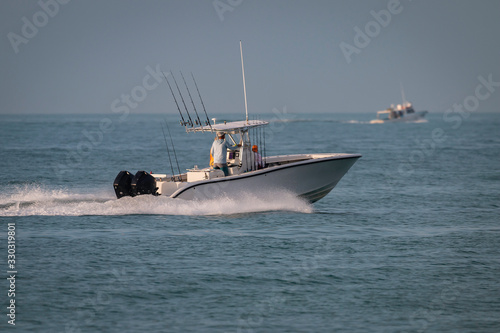 A sport fishing boat races to the next location to make the catch of the day.