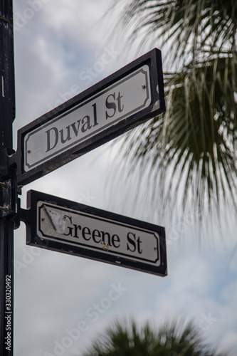 Street sign at the corner of Duval Street and Greene Street in the heart of the party area of Key West, Florida