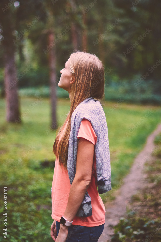 Fototapeta premium Beautiful young woman walks in the park