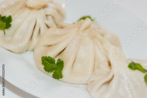  Delicious appetizing traditional homemade manti on a white plate. Close-up.