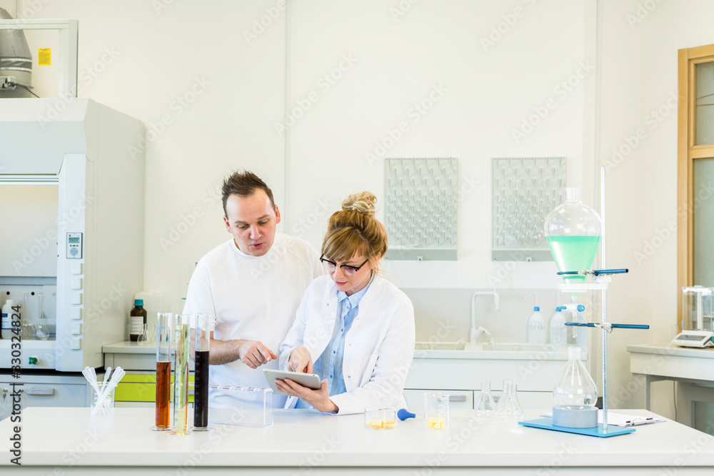 Obraz premium Two scientist working with tablet in CBD hemp laboratory