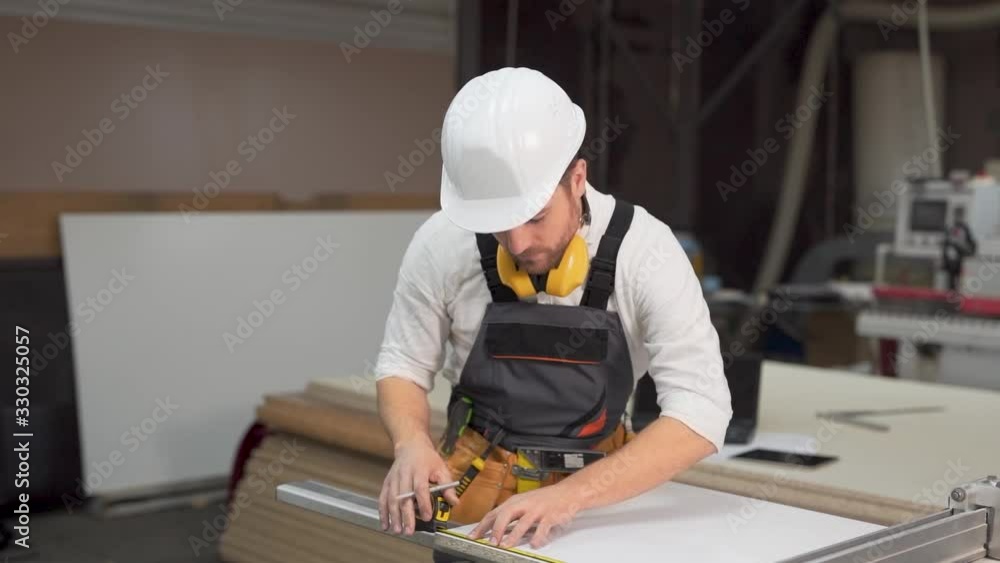 the working joiner measures the tape measure board the working joiner measures the tape measure board