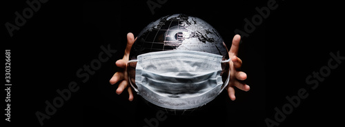 Kid holding globe map sphere isolated on black horizontal background. Ecological problems disasters. COVID-19 pandemic infection disease concept image, copy space for text photo