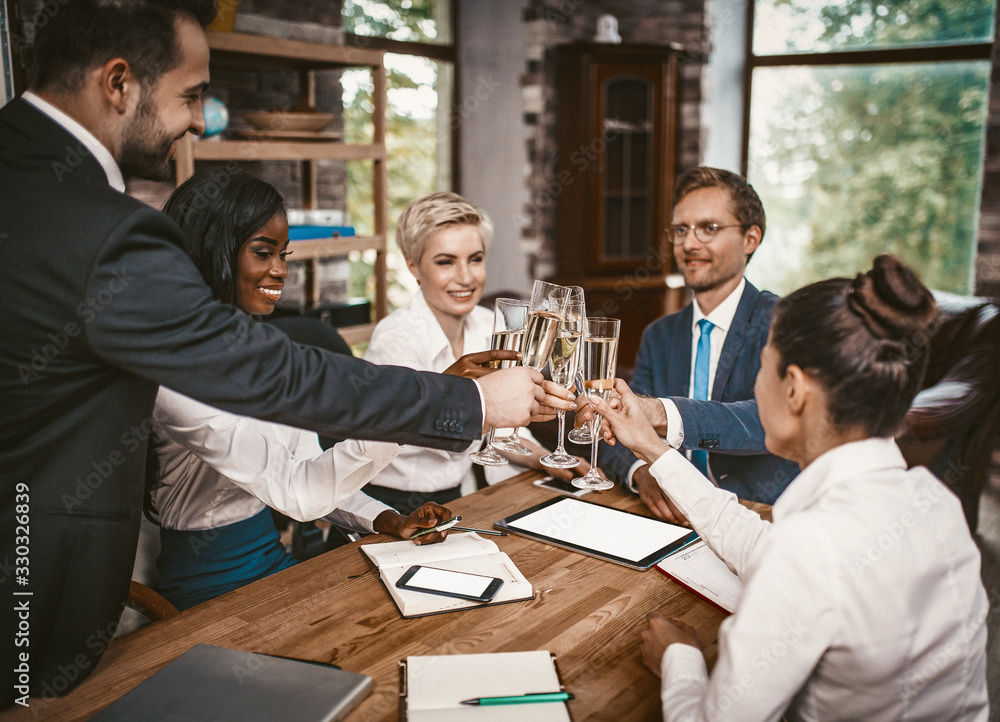Business Event In Office, Diverse Team Rejoice And Having Champagne After Agreement Signing While Sitting Around Table, People holding Wineglasses in Hands And Smiling, Toned Image Business Event In Office, Diverse Team Rejoice And Having Champagne After Agreement Signing While Sitting Around Table, People holding Wineglasses in Hands And Smiling, Toned Image