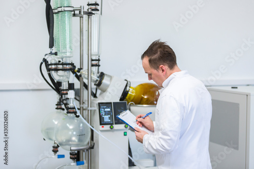 Scientist controlling rotavapor machine during CBD and CBDa oil extraction