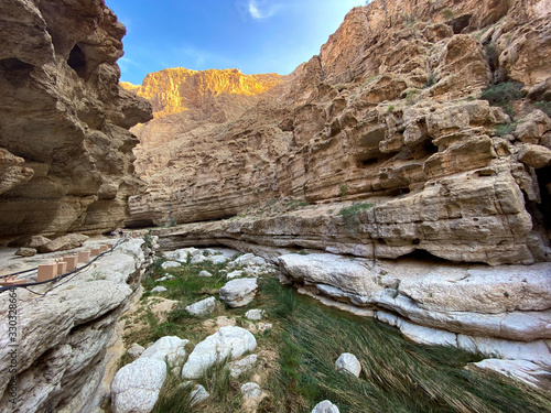 Wadi Shab river canyon, Sultanate of Oman. Natural mountain landscape with green water river and vertical rocky cliffs. photo