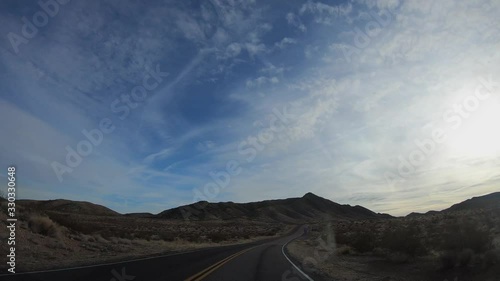 4K. POV view of car driving on road at sunny day in USA. Drive on an empty road in the dark evening. Asphalt with yellow line at new road in Valley of Fire. Nevada state.