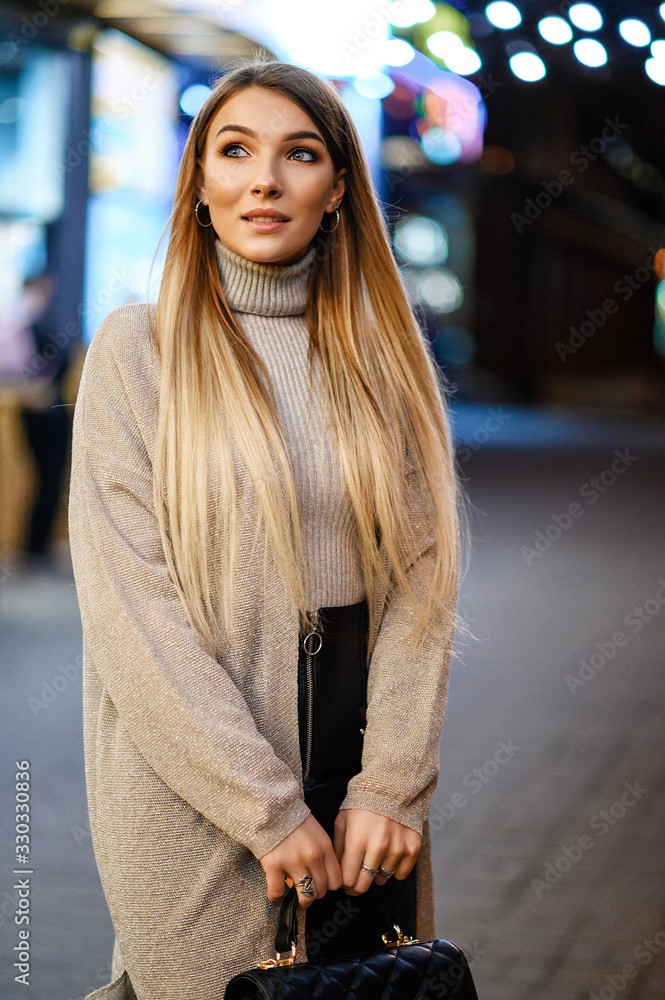 Fototapeta premium Attractive blonde posing against the backdrop of the night city
