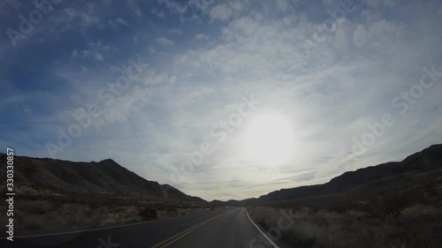 4K. POV view of car driving on road at sunny day in USA. Drive on an empty road in the dark evening. Asphalt with yellow line at new road in Valley of Fire. Nevada state.