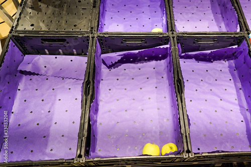 empty and plundered fruit bins in a European supermarket with few apples because of Covid-19 panic and fear photo