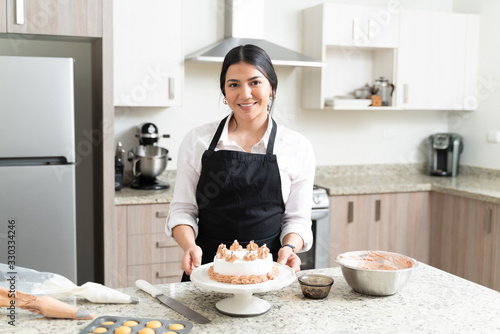 Beautiful Young Baker With Desert On Counter At Home