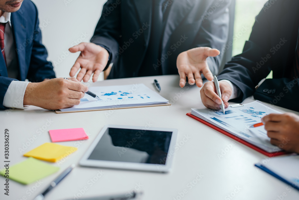 Businessman pointing to a document graph during a business meeting. Businessman pointing to a document graph during a business meeting.