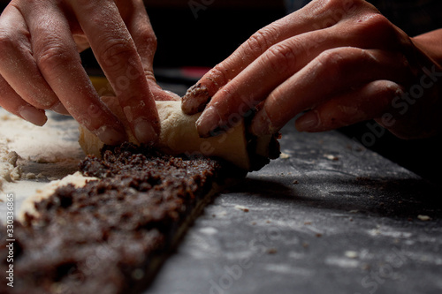 Baker prepares homemade cakes. Professional Female cook sprinkles dough with flour, prepared for baked bread