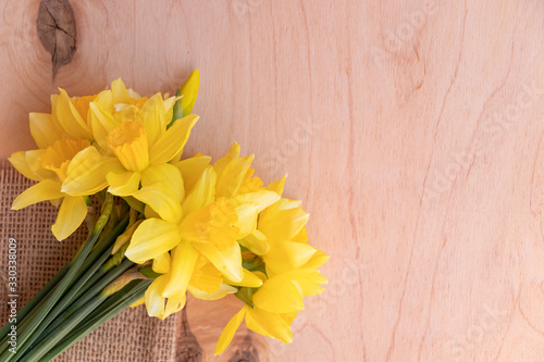 Yellow daffodils on a wooden background. Bouquet of spring flowers. Warm weather.