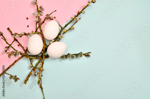 White eggs with green myrtle leaves pattern on vibrant pastel color background. Spring and Easter holiday concept with copy space.