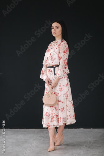 Young brunette model demonstating spring clothes in studio photo