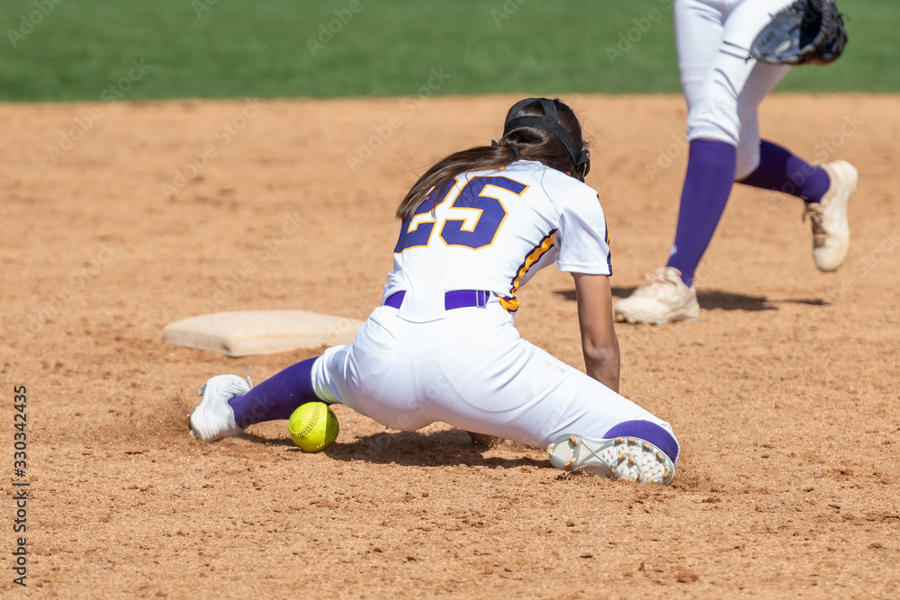 Girl Fastpitch Softball player in action during a competitive game Girl Fastpitch Softball player in action during a competitive game
