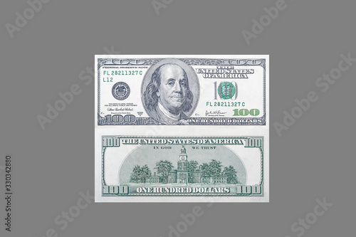 Front and back side of one hundred US dollar banknote with portrait of american president benjamin franklin on isolated gray background