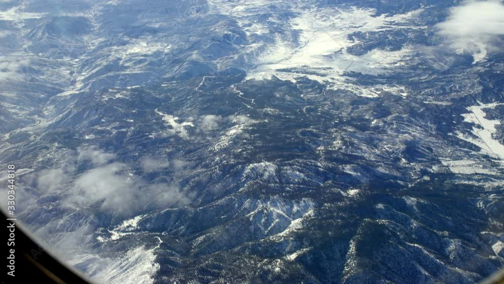 Snowed Mountains over northern California during winter, Aerial airplane window shot Snowed Mountains over northern California during winter, Aerial airplane window shot