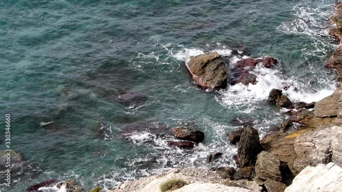 El mar rompe con suavidad sobre las rocas de un acantilado en las calas rocosas del sur de España, en la Costa Tropical de Granada, 
