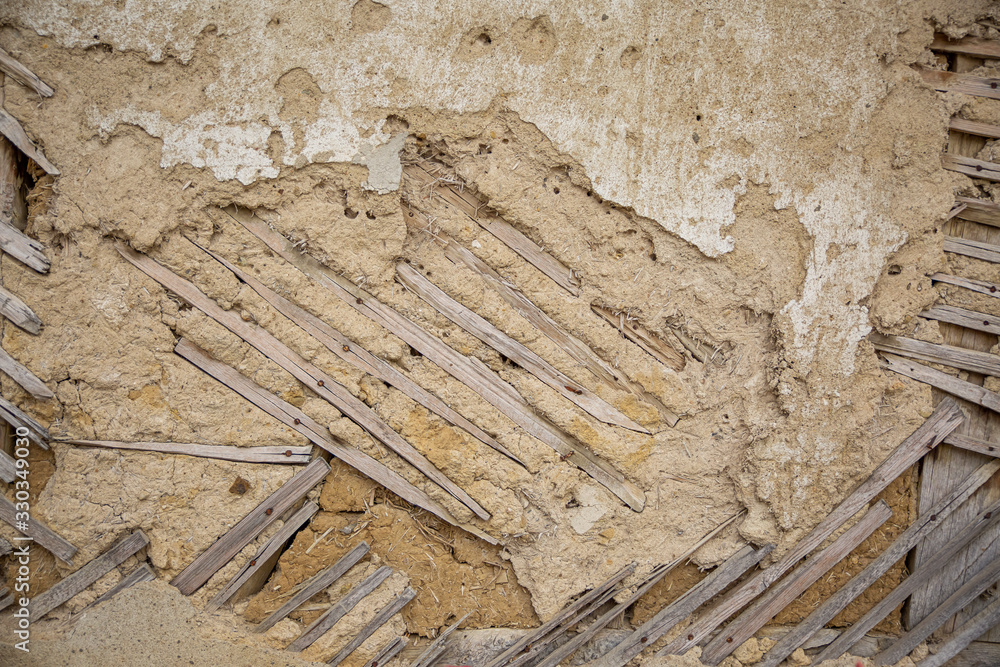 Close up of cracked adobe wall texture, clay wall from a mud house. Close up of cracked adobe wall texture, clay wall from a mud house.