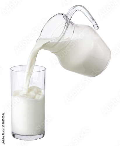 Pouring milk from jug into glass isolated on white background